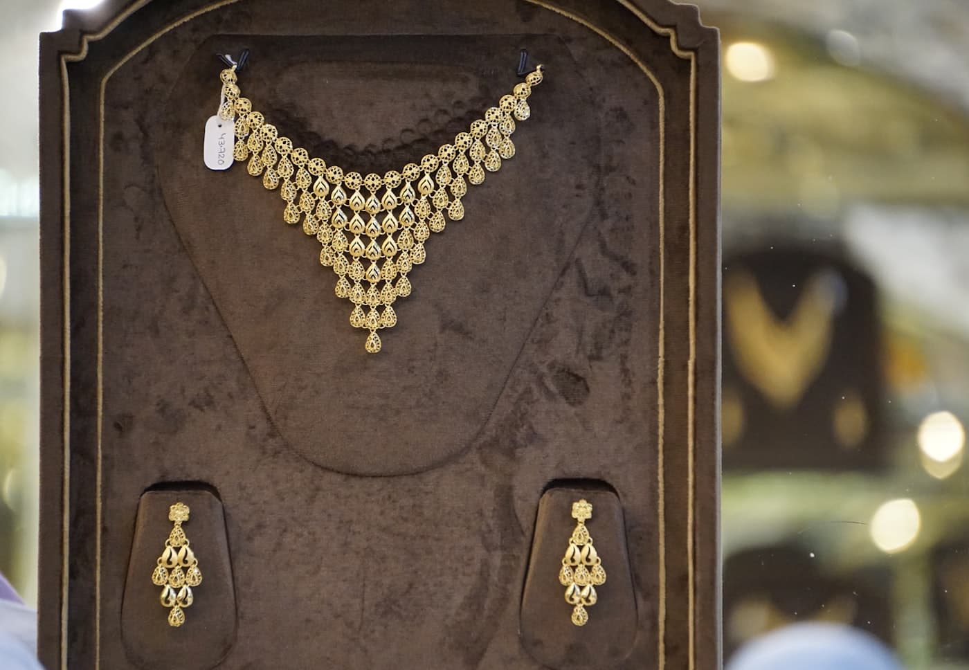 A gold necklace and matching earring set on display